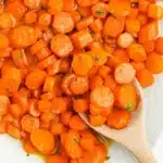 A close-up of candied carrots in a skillet.