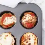 Baked turkey meatloaf muffins with tomato sauce and cheese in a muffin tray