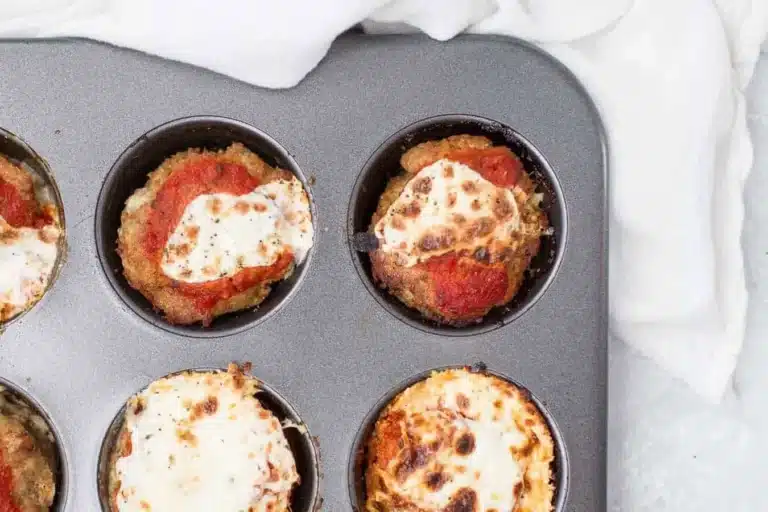 Baked turkey meatloaf muffins with tomato sauce and cheese in a muffin tray