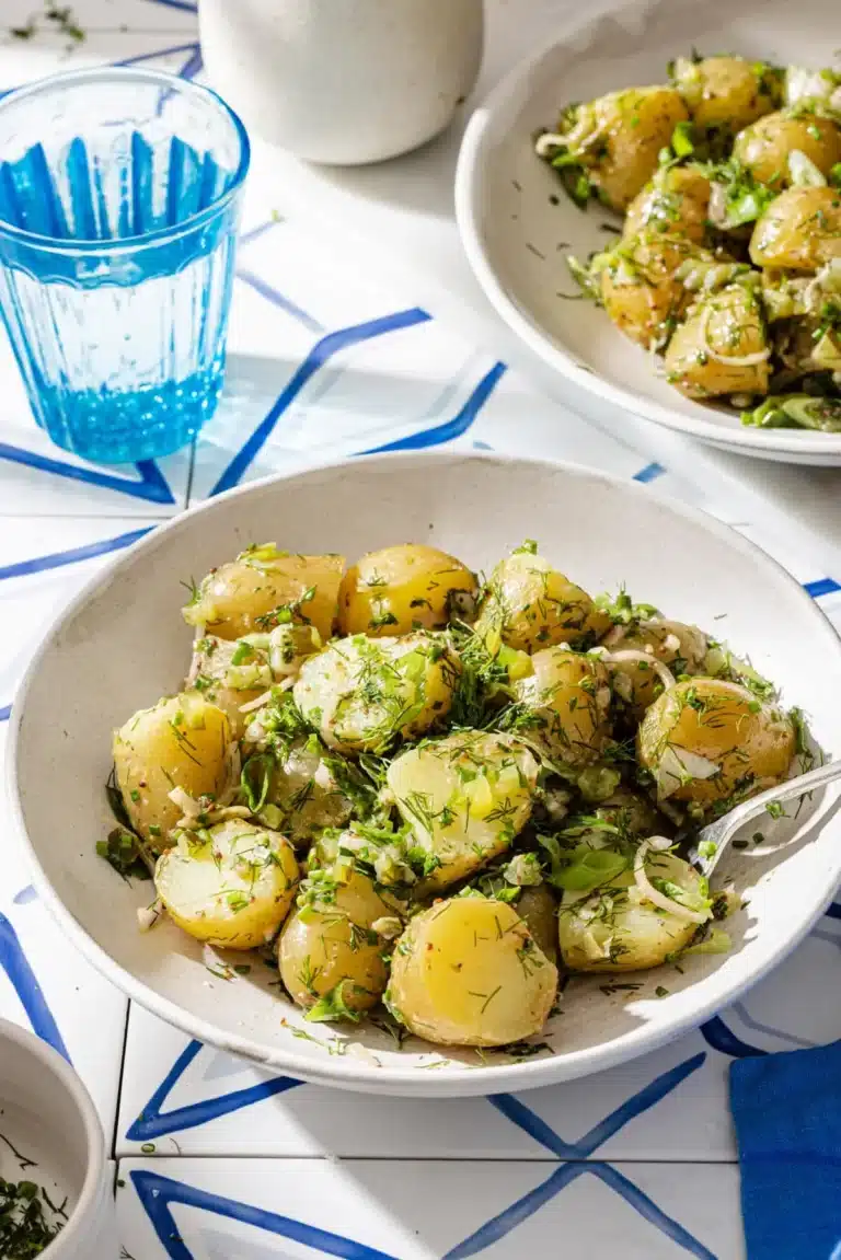 A plated serving of French potato salad with a fork, ready to eat