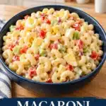Creamy elbow macaroni salad with colorful vegetables in a navy serving bowl