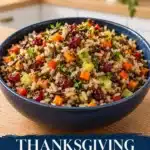 Wild rice pilaf with cranberries, carrots, bell pepper, leeks and herbs in a navy bowl